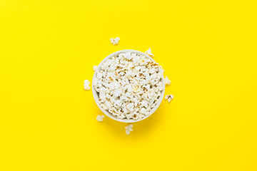 Bowl with popcorn on a yellow background. Flat lay, top view