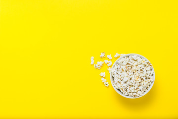 Bowl with popcorn on a yellow background. Flat lay, top view