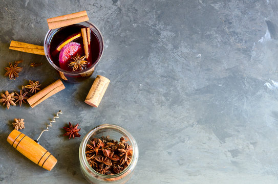 Glass Of Homemade Mulled Wine , Red Wine Bottel And Different  Spices On Grey Background. Perfect Winter Beverage For Cold Days.Top View