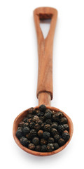 Black peppers on wooden scoop