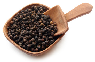 Black peppers on wooden bowl