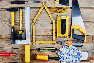 set of construction tools on a wooden background top view