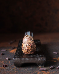 Homemade chocolate truffle with blue cheese and white chocolate on dark background. Close up. Selective focus. Delicious dessert. Confectionery recipe.