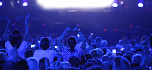three girls at live concert with blue lights
