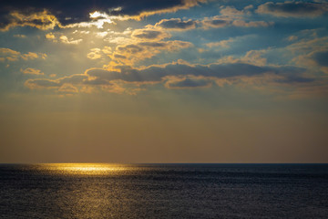 Fototapeta premium Seascape with bright moon and clouds. A golden reflection of light on the sea surface.