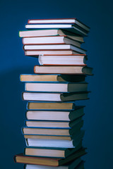 Books stack on a dark background, twilight lighting