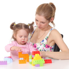 mother plays with her daughter with developing toys