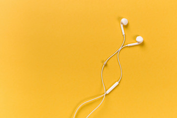 White earphones on orange background