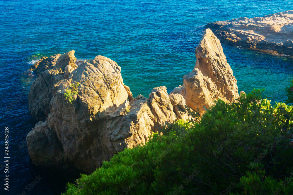 Wall mural view on blue sea with rocky cliff in water in lloret de mar, costa brava, spain - Wall murals