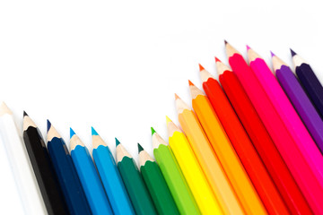 Colour pencils on white background, top view.