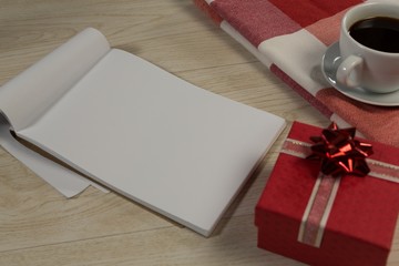 Gift box, notepad, textile and black coffee on wooden table