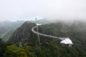 Aerial view of the Sky Bridge on Langkawi Island, Malaysia. People walk on a curved bridge high above the sea in the mountains