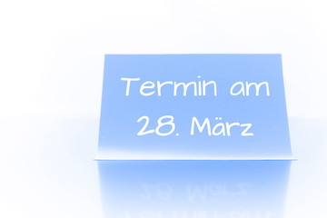 Termin am 28. März - blauer Zettel mit Notiz