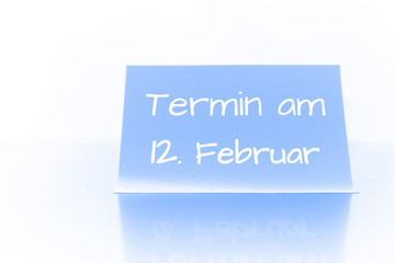 Termin am 12. Februar - blauer Zettel mit Notiz