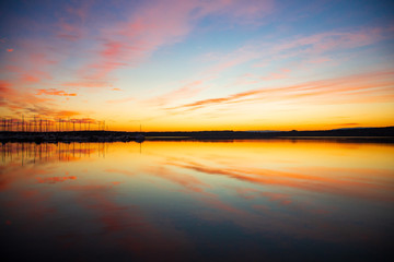 Fototapeta na wymiar Sonnenuntergang, im Vorderund ein Hafen, Schiffe, Marina