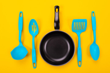 Kitchen utensils for cooking in kitchen isolated with copyspace on yellow background