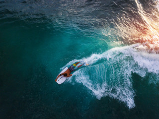 Obraz premium Bodyboard surfer rides tropical wave at sunset