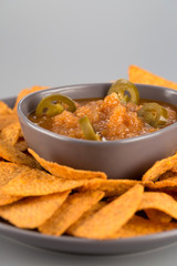 Nachos on a plate with hot sauce. Mexican appetizer.