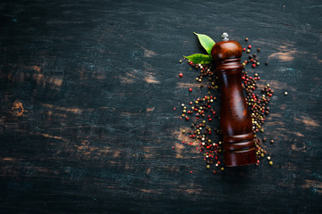 Mill pepper and pepper. Spices Top view. On the old background.