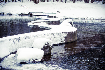 A small waterfall on the river in the winter Park 