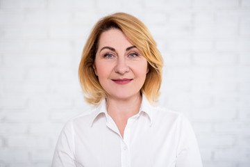 close up portrait of mature woman over white wall