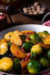 Brussels sprouts potato pan with bacon in rustic style