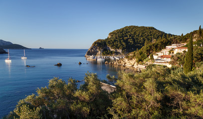 Naklejka premium View to the sea bay with yachts and boats in crystal clear azure water at Paleokastritsa. Panoramic landscape. Corfu island, Greece. Holidays in Greece.
