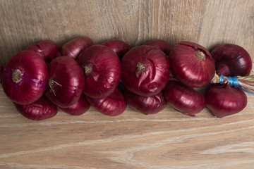 Onion on a wooden background. Purple onions. Bunch of onions.
