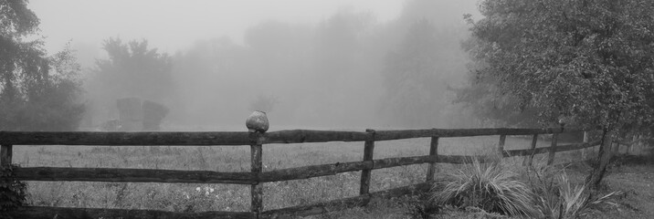 wooden fence on the meadow in the fog.  Banner for design.