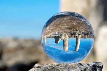 Fototapeta na wymiar Upside down landscape of Pobiti Kamani, The Stone Forest Natural Reserve near Varna in Bulgaria, Eastern Europe - reflection in a lens ball - selective focus, space for text