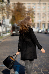 Spring portrait of cool young woman enjoying warm weather, wearing coat and jeans