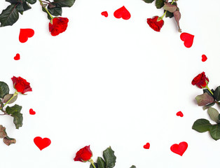 Frame of red rose flowers and decorative hearts on white background. Place for text, top down composition.