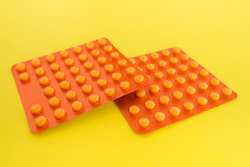 Two blisters with vitamin C on a yellow background close up. Two packs of vitamins or pills. The concept of health care and pharmaceuticals.