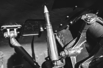 Shell missile is lying on old metal green cannon from the time of Second World War. Weapon for...