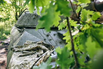 Shell missile is lying on the old khaki jacket. Historical things on armored fighting vehicle. Rusty dye of tank background texture.