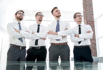 group of employees standing in an office and looking at a copy space