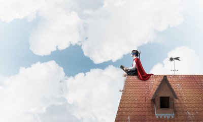 Girl power concept with cute kid guardian against cloudscape bac