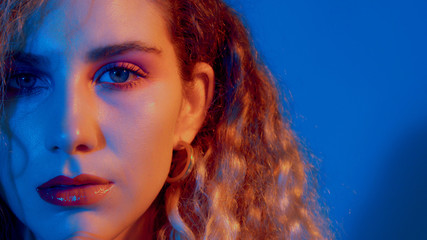 half of a face of model in blue-red coloured light