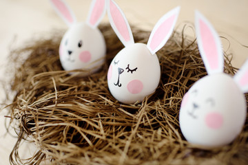 Happy Easter. Eggs with ears of rabbits in a nest on a white background.