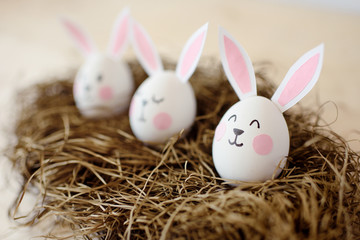 Happy Easter. Eggs with ears of rabbits in a nest on a white background.