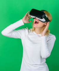 A person in virtual glasses flies in room space. Person with virtual reality helmet isolated on green background. Woman using virtual reality headset.