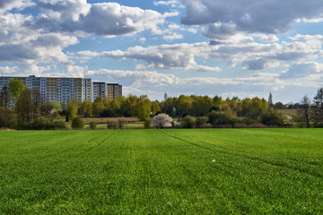 Fototapeta na wymiar Meadows and arable fields and a housing estate during spring in Poznan.