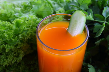 Carrot juice with greens on a wooden board