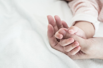 New Born Baby hand hold finger of mom: concept of love, take care, parent relationship