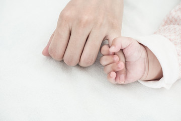 New Born Baby hand hold finger of mom: concept of love, take care, parent relationship