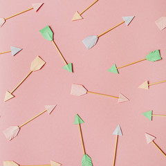 Paper Cupid arrows on pink background. Flat lay, top view Valentines Day background love concept.