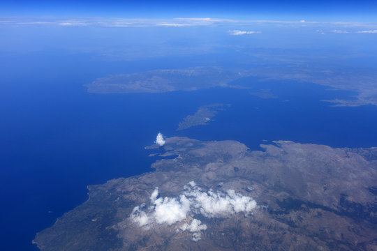 Top view of a flying aircraft on the sky, sea and land