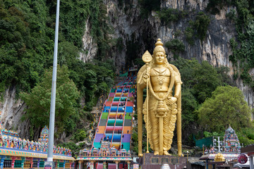 The Batu Caves Lord Murugan Statue and entrance near Kuala Lumpur Malaysia. A limestone outcrop located just north of Kuala Lumpur, Batu Caves has three main caves featuring temples and Hindu shrines.