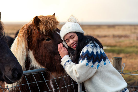 Woman cuddling with Icelandic horse on Iceland road trip - Powered by Adobe