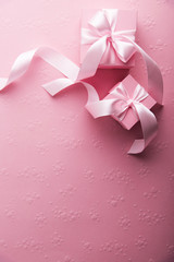 Valentine's Day. Pink gifts, presents tied with rosy ribbon on pink heart shape patterned background top view. Valentines Day, 8 March, Women's Day, Birthday, Mother's Day holiday background